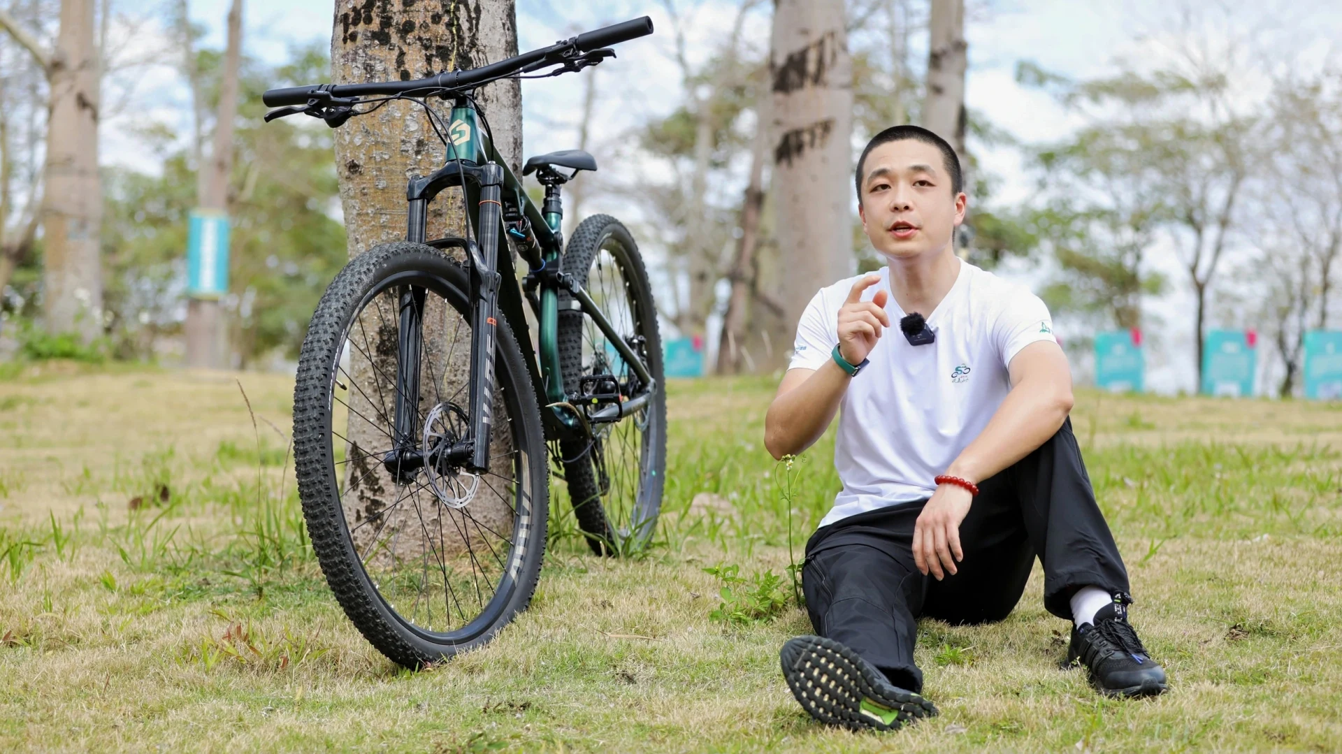草地上坐在自行车旁的男性人物