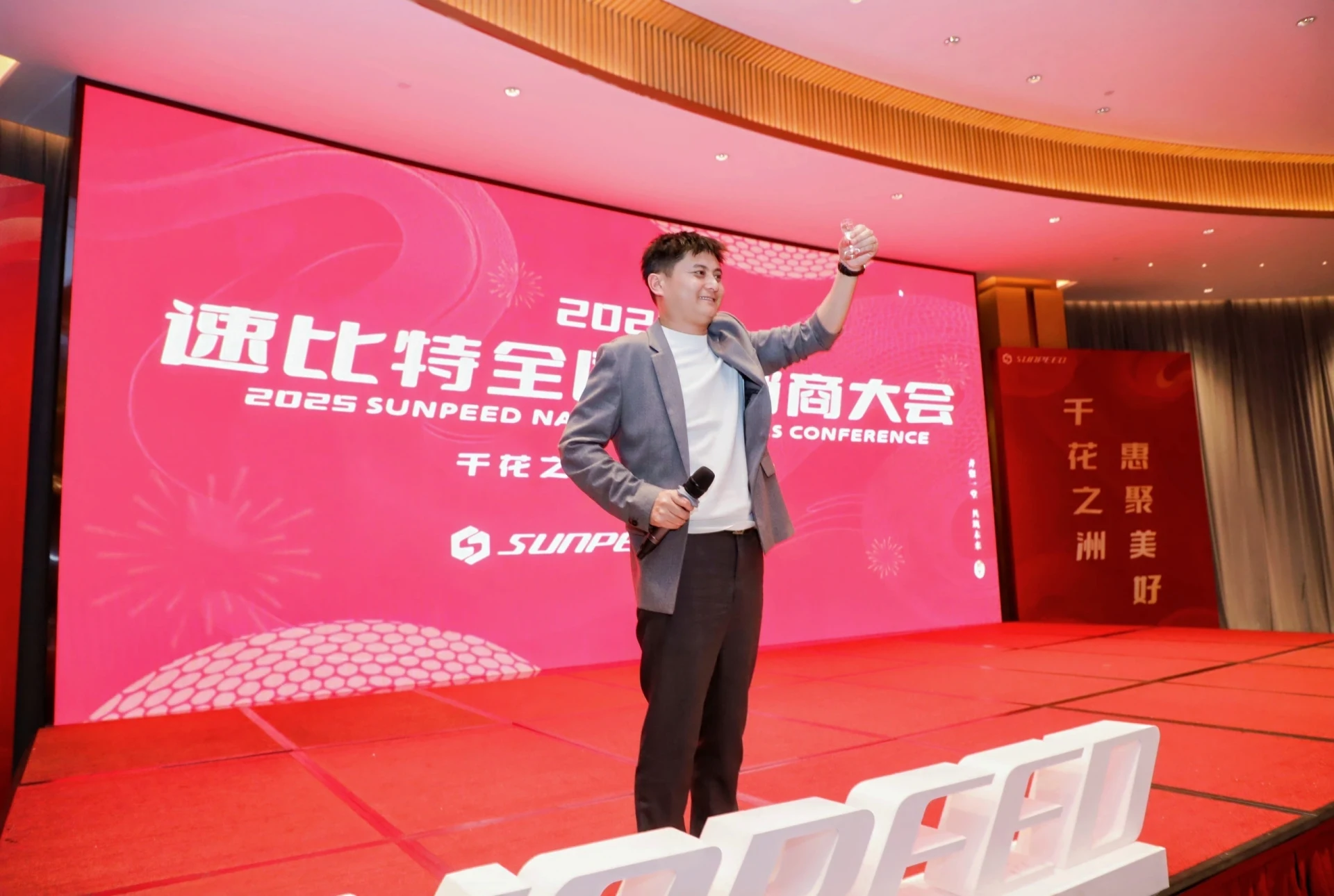 红色发布会舞台上持麦克风演讲的人物
