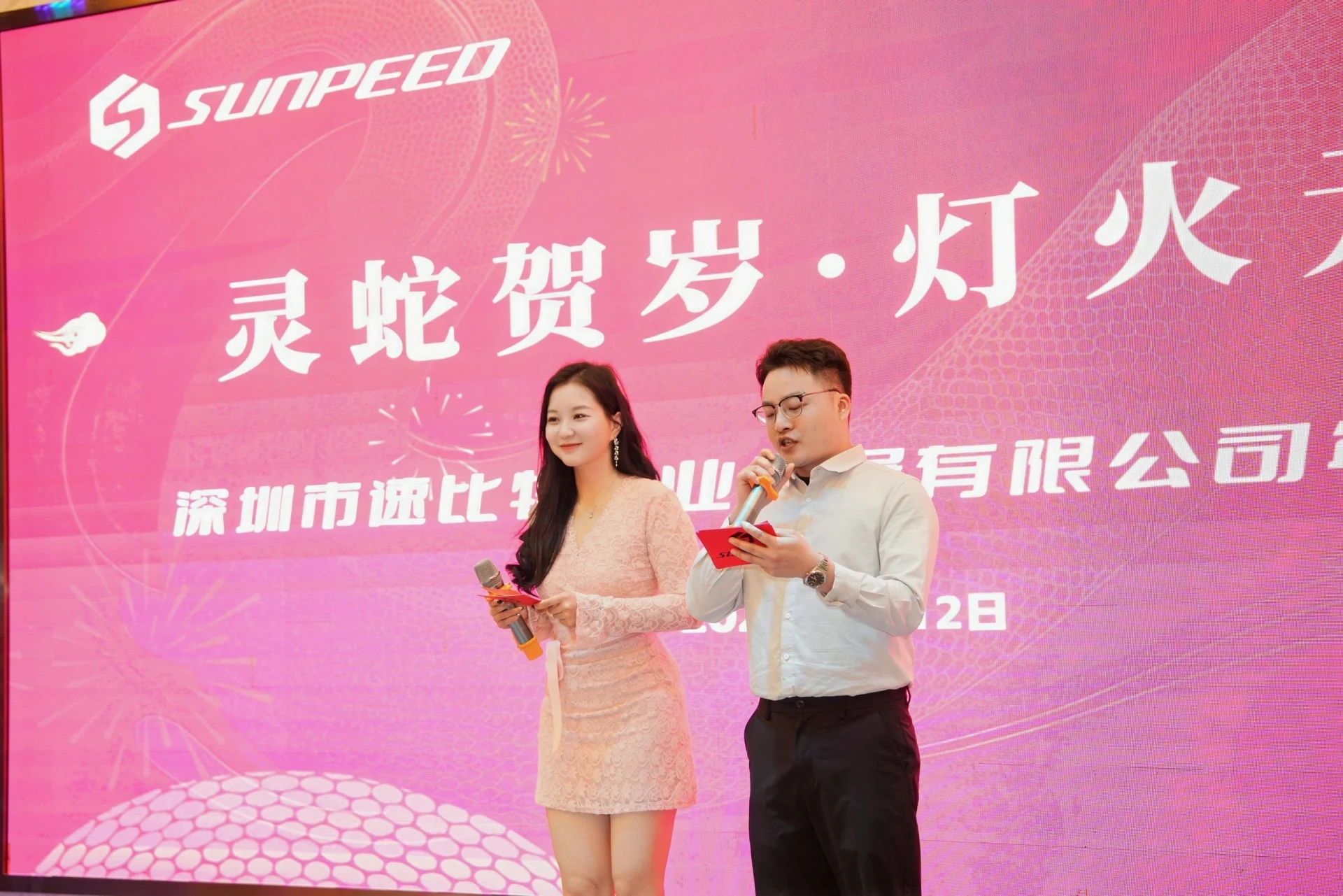 节庆舞台上持麦克风的两位主持人